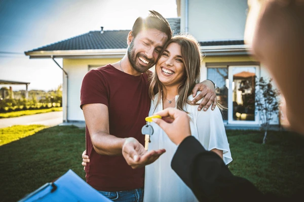 Happy couple receiving house keys after FHA loan approval.